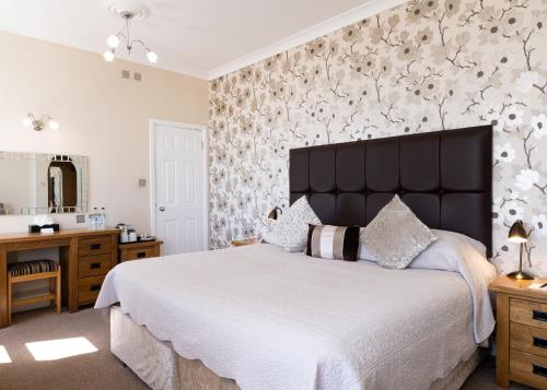 a bedroom with a large bed and a bathroom at Langham Hotel Eastbourne in Eastbourne