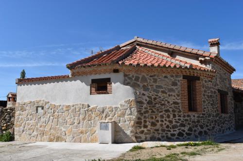 une maison en pierre avec un mur en pierre dans l'établissement Casa Rural El Balcón de Piedrahíta, à Navahermosa de Corneja