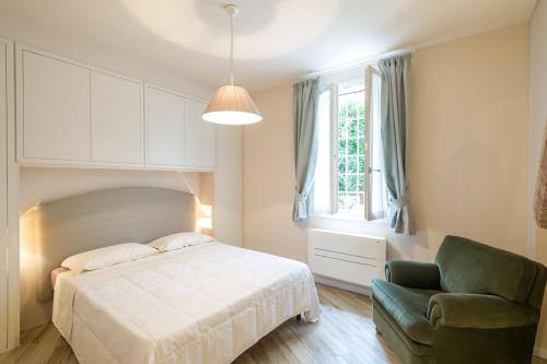 a bedroom with a bed and a chair and a window at La Residenza dei Piaceri Perduti- Le Volte in Lastra a Signa