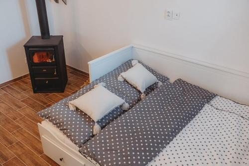 a bed with pillows and a stove in a room at Vinný sklep Rozárka in Drnholec