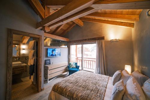 une chambre avec un lit, une télévision et une fenêtre dans l'établissement chalet Polar, à Chamonix-Mont-Blanc