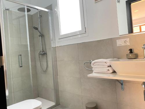 uma casa de banho com um chuveiro, um lavatório e um WC. em Hispalis Jardines de Murillo em Sevilha