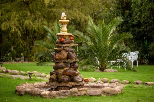 a stone fountain in the middle of a yard at Hospedaje Villa Eucalyptus in Nobsa