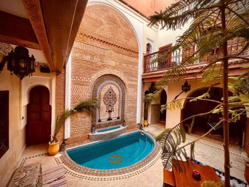 una piscina in un edificio con una casa di Riad Bonheur a Marrakech