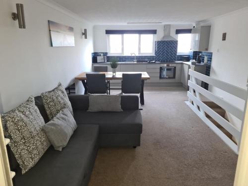 a living room with a couch and a table and a kitchen at Beautiful 3 bed house in Hunstanton - near Searles with sea views in Hunstanton