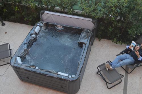 a woman sitting in a chair in front of a hot tub at Antica Pusterla Relais de Charme in Vicenza