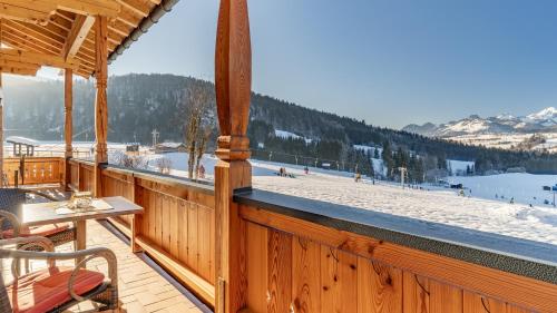a wooden balcony with a table and a ski slope at Demelhof in Reit im Winkl