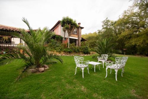 a group of chairs and a table in a yard at Hospedaje Villa Eucalyptus in Nobsa
