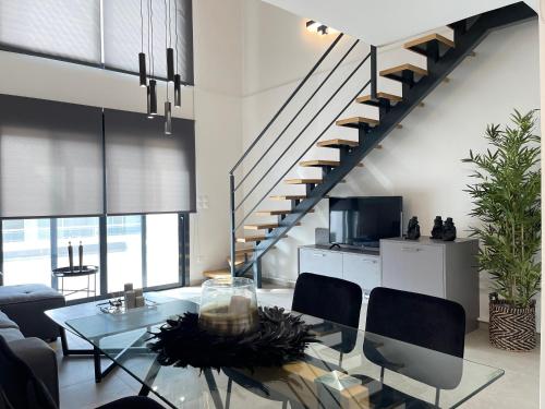 a living room with a glass table and a staircase at Athenean Modern Escape near Marina Flisvos in Athens