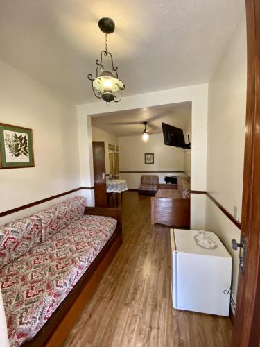 a bedroom with a bed and a living room at Hotel Fazenda São Moritz in Teresópolis