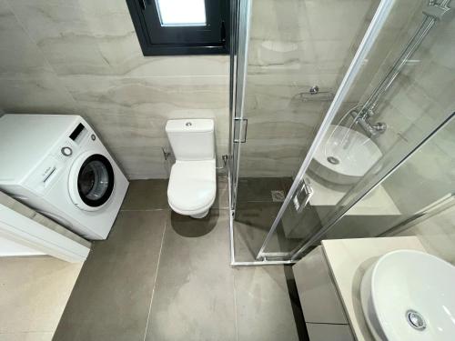 a bathroom with a toilet and a sink and a shower at Athenean Modern Escape near Marina Flisvos in Athens
