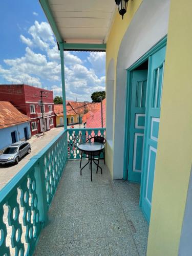 balcón con mesa y vistas a la calle en Casa Ramona en Flores