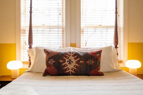 a bedroom with a large bed with two windows at The Vesper Woodstock in Woodstock