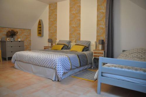 ein Schlafzimmer mit einem großen Bett mit gelben Kissen in der Unterkunft Les Hortensias in Gatteville-le-Phare