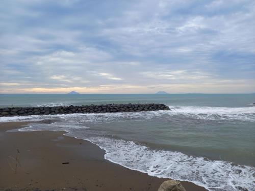 a beach with waves crashing on the shore at Shambala palm beach anyer in Anyer
