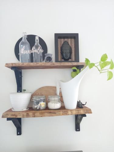 a shelf with bowls and bottles on a wall at Shambala palm beach anyer in Anyer