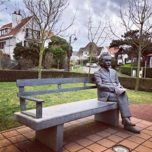 a statue of a man sitting on a bench at Zalig Cosy appartement 2-4 pers.fietsen & tuin in De Haan