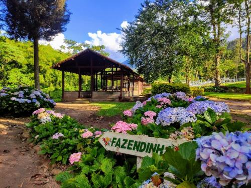 a garden with flowers and a gazebo at Hotel Fazenda São Moritz in Teresópolis
