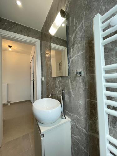 a bathroom with a white sink and a mirror at Athenean Modern Escape near Marina Flisvos in Athens