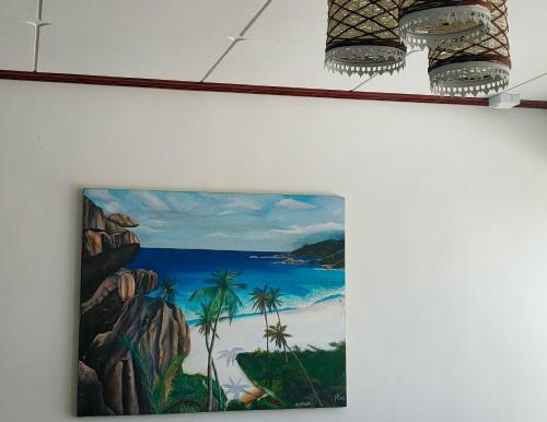 a painting of a beach on a wall at MT Seaside Apartment in La Digue