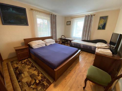 a bedroom with two beds and a television in it at Nida Lotmiškio 15 in Nida