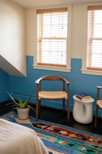 a bedroom with a chair and a blue wall at The Vesper Woodstock in Woodstock