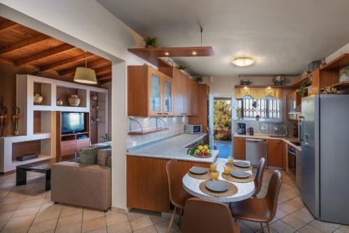 a kitchen and dining room with a table and chairs at Villa René in Koskinou