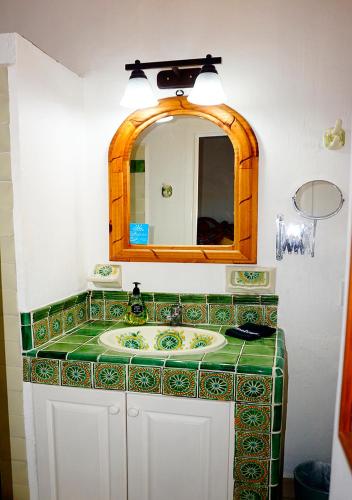 a bathroom with a sink and a mirror at Casa del Sol Inn in Ajijic