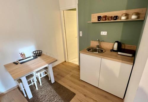 a small kitchen with a sink and a table at Guest House Time Out in Sarajevo