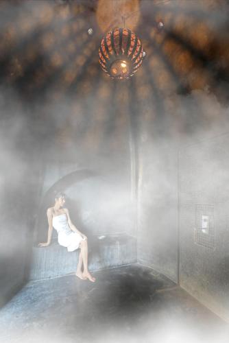 a woman in a white dress sitting on a wall at DAR NOUJOUM in Marrakech