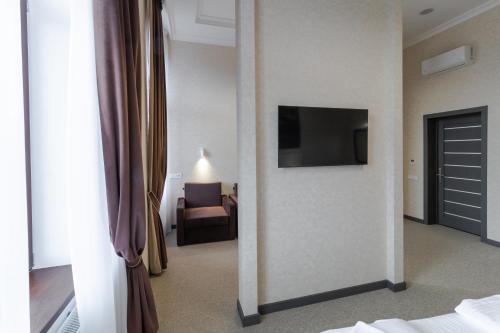 a hotel room with a television on a wall at Opera Passage Hotel & Apartments in Lviv