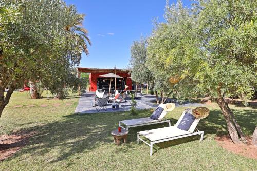 a yard with chairs and a house with trees at DAR NOUJOUM in Marrakech