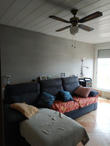 ein blaues Sofa im Wohnzimmer mit Deckenventilator in der Unterkunft apartamento en la pineda in La Pineda