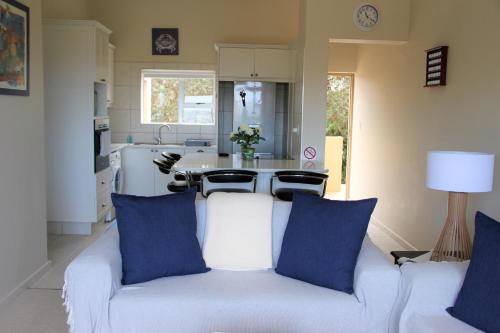 a white couch with blue pillows in a kitchen at W8 - Goose Valley Golf Estate in Plettenberg Bay