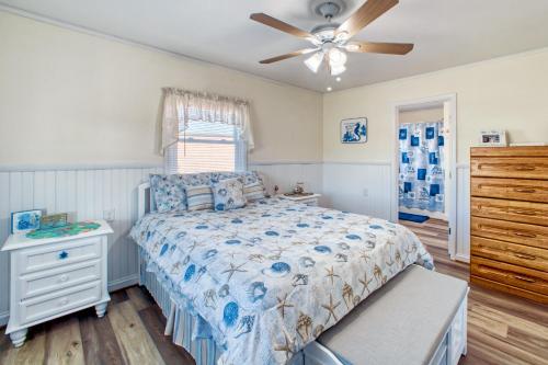 a bedroom with a bed and a ceiling fan at Cottage on 12 in Hatteras