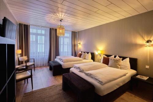 a hotel room with two beds and a television at Hotel Roter Hahn in Regensburg