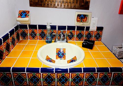 a bathroom with a sink with colorful tiles at Casa del Sol Inn in Ajijic