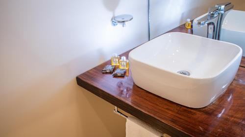 a bathroom with a white sink on a wooden counter at Moonshine Tulum Hotel & Hostel in Tulum
