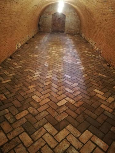 a brick hallway with a light at the end of a tunnel at Vinný sklep Rozárka in Drnholec
