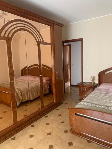 a bedroom with a bed and a large mirror at Appartamento incantevole a pochi passi dal mare, Locazione breve turistica privata, no impresa in Capo dʼOrlando