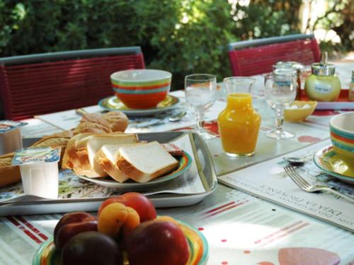 - une table avec une assiette de nourriture et de fruits dans l'établissement Louminai, à Donzère
