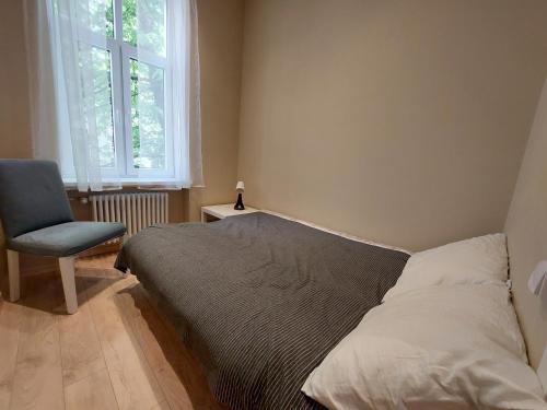 a bedroom with a bed and a chair and a window at Cosy one seperate bedroom apartment in city center, perfect for family trip. in Riga