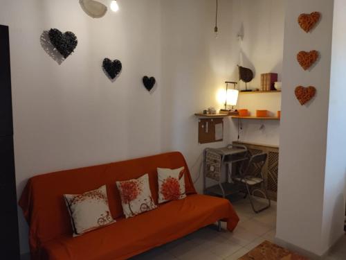 ein Wohnzimmer mit Sofa und Herzen an der Wand in der Unterkunft Cagliari Elmas Airport Beautiful Mansarda in Assemini