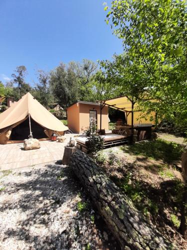 a building with a tent in a yard at Agriturismo e Glamping Serraiola Alta in Frassine