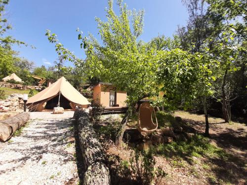 a tent in the middle of a yard with trees at Agriturismo e Glamping Serraiola Alta in Frassine