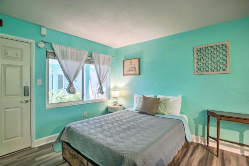 Dormitorio azul con cama y ventana en Tropical Pass-A-Grille Gem with Direct Beach Access!, en St Pete Beach