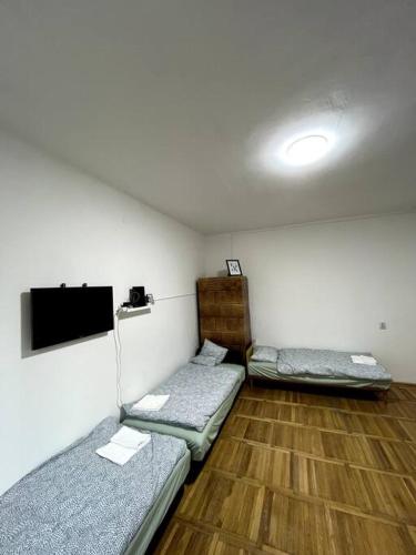 a room with two beds and a flat screen tv at Hangulatos lakás Budapest zöld övezetében in Budapest