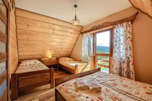 a bedroom with two beds and a window at Jakubowy Domek in Cisna