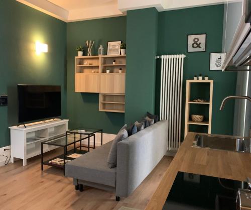 ein Wohnzimmer mit einem Sofa und einem TV in der Unterkunft Apartment Hotel Marchesini in Ravenna