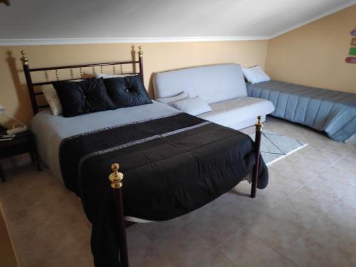 a bedroom with a bed and a couch at Casa de Vasco in Amora